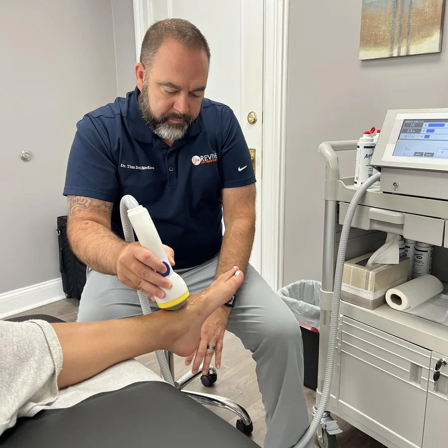 Dr. Tim DelMedico, DC, treating a patient at Revive Health